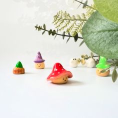 small wooden gnomes are lined up next to a plant