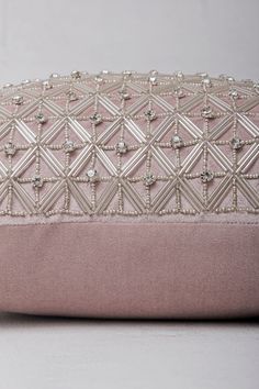 a pink and white clutch bag sitting on top of a table next to a wall