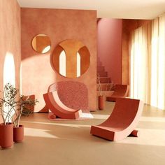 a living room filled with furniture and potted plants in front of a wall mounted mirror