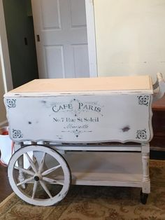 an old cart is painted white and has the words cafe paris on it