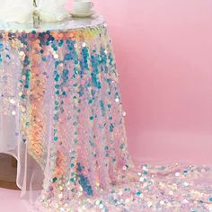 a table covered with sequins and a white vase