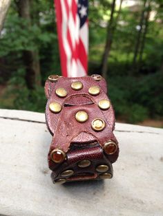 Made from a cool detailed leather belt, a handmade and unique cuff. This bracelet has all the right bling, sparkly amber colored jewel grommets. Yes one of the amber colored jewels is missing, but that just adds to the recycled worn look of the bracelet. You can see the missing jewel in the first picture. It in no way takes away from the bracelet. 7 inches long 1 & 1/4 inches wide Vintage Leather Bracelet With Rivets, Vintage Adjustable Leather Bracelet With Rivets, Vintage Leather Bracelet With Custom Hardware, Adjustable Vintage Leather Bracelet With Rivets, Unique Leather Cuff Bracelet For Festival, Brown Leather Cuff Jewelry, Adjustable Cuff Bracelet With Rivets As Gift, Unique Brown Cuff Jewelry, Vintage Leather Bracelets With Rivets