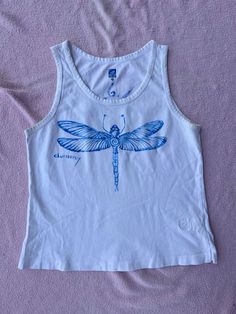 a white shirt with a blue dragonfly on it