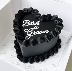 a black heart shaped cake sitting on top of a white box