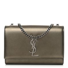 This is an authentic SAINT LAURENT Grain De Poudre Small Monogram Kate Satchel in Gold. This stylish handbag is crafted of finely pebbled calfskin leather in a light metallic gold. The shoulder bag features a polished silver chain-link shoulder strap and a full-facing flap with the classic polished silver YSL logo. This opens to a black fabric interior with a leather pocket. Luxury Gold Shoulder Bag With Palladium Hardware, Luxury Gold Bag With Palladium Hardware, High-end Gold Shoulder Bag For Everyday, Luxury Silver Shoulder Bag With Metal Logo, Luxury Silver Shoulder Bag With Gold-tone Hardware, Luxury Gold Calf Leather Shoulder Bag, Designer Metallic Bags For Formal Occasions, Gold Shoulder Bag With Palladium Hardware For Evening, Luxury Gold Bags With Metal Logo