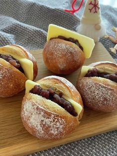 four pastries on a wooden board with cheese