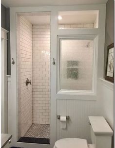 a white toilet sitting next to a walk in shower