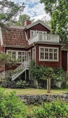 a red house surrounded by trees and bushes