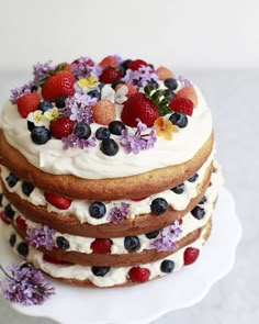 the cake is decorated with fresh berries and blueberries