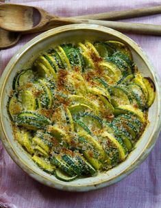 a casserole dish with zucchini and parmesan cheese