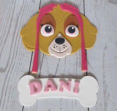 a cake topper with a dog's head and bone on the bottom that says dani