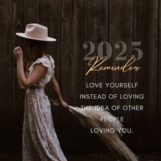 a woman in a white hat and dress holding a long brown feather with the words, reminder love yourself instead of loving the idea of other people living you