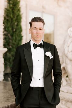 a man in a tuxedo poses for the camera