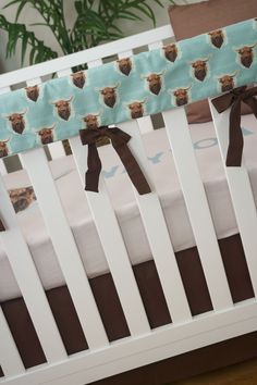 a crib rail cover with moose head and brown bow ties on it's sides