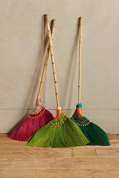 three brooms with different colors and designs on them