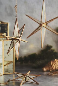 three wooden stars hanging from chains on a table next to other ornaments and decorations,