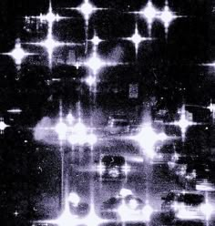 black and white photograph of cars driving down the road with stars in the sky above them