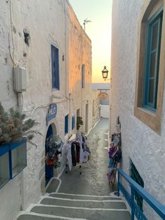 an alley way with clothes hanging out to dry on the side and blue shutters