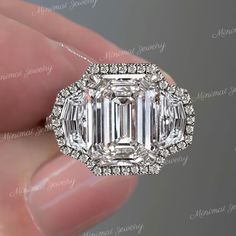 an emerald cut diamond surrounded by round and baguette diamonds in a halo setting