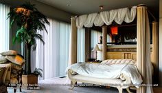 a bed sitting in the middle of a bedroom next to a tall potted plant