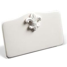 a white ceramic business card holder with a fleur de lis on the front