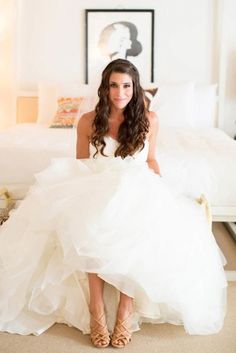 a woman in a wedding dress sitting on a bed