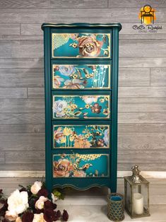 an old dresser has been painted with flowers and gold leaf designs on the drawers, along with some candles