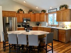 a large kitchen with wooden cabinets and stainless steel appliances in it's center island