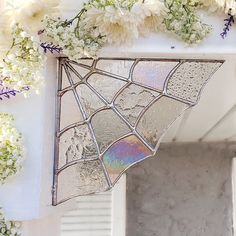 an old stained glass window with white flowers on the outside and in the inside,