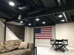 a living room with an american flag hanging on the wall next to a couch and table