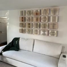 a white couch sitting in front of a wall with pictures on it