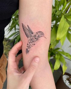 a small hummingbird tattoo on the arm