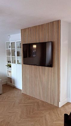 a flat screen tv mounted to the side of a wall in an empty living room