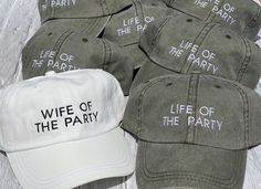 five baseball caps with the words life of the party written in white ink on them