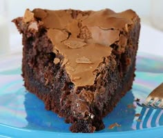 a piece of chocolate cake sitting on top of a blue plate next to a fork