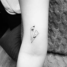 a black and white photo of a small tattoo on the left inner arm, with an origami in it