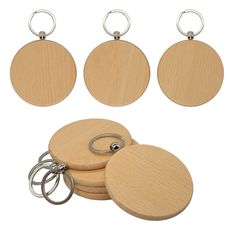 four wooden keyrings with metal rings on each one and two circular tags attached to them