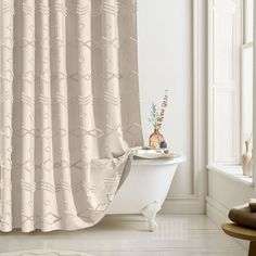 a bath tub sitting next to a shower curtain in a white room with an open window