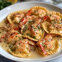 a white bowl filled with pasta covered in shrimp