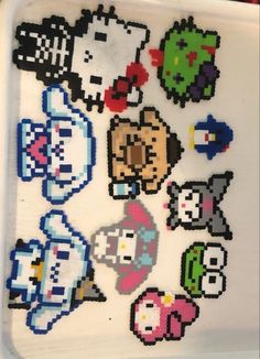 an assortment of pixel art stickers on a white tray with red and blue trim