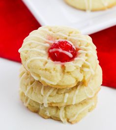 three cookies with white icing and a cherry on top