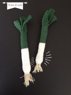 two green and white crocheted hand warmers sitting on top of a table