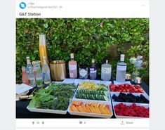 a table topped with lots of different types of fruits and veggies next to bottles of alcohol