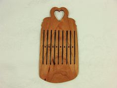 a wooden cutting board with a heart shaped cutout on the front and bottom of it