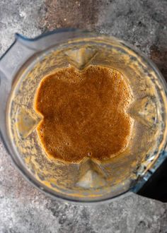 a blender filled with brown liquid on top of a table