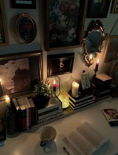 a table topped with books and candles next to pictures