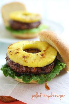 two hamburgers with pineapple and meat on them