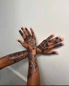 several hands with henna tattoos on them