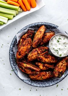 chicken wings with ranch dressing and carrots on the side