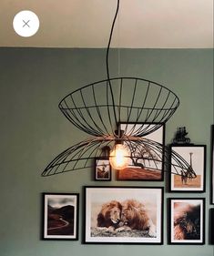 a room with pictures on the wall and a light fixture hanging from it's ceiling